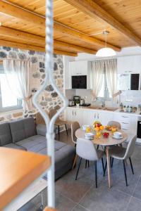Una cocina y una sala de estar con una mesa. en Marilena Natural Stone House, By Hellocrete, en Pigi