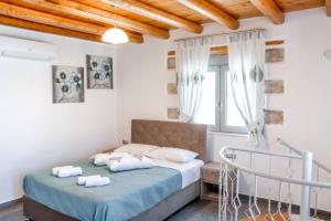 Un dormitorio con una cama y una ventana en Marilena Natural Stone House, By Hellocrete, en Pigi