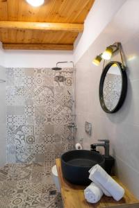 un baño con lavabo y espejo en Marilena Natural Stone House, By Hellocrete, en Pigi