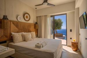 a bedroom with a bed with a view of the ocean at ArtOikia Luxury Villas, By Hellocrete in Saktoúria +131 photos