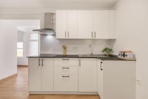 une cuisine blanche avec des armoires blanches et un évier dans l'établissement El Hierro, à La Victoria de Acentejo