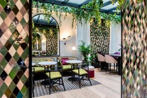 a restaurant with tables and chairs and plants at Best Western Plus Crystal, Hotel,Bar & Spa in Nancy