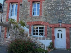 ein Backsteinhaus mit einer weißen Tür und einer Treppe in der Unterkunft 670 - Belle maison en pierre – parfaite pour partager des moments en famille in Erquy