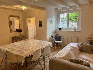 ein Wohnzimmer mit Tisch und Couch in der Unterkunft 670 - Belle maison en pierre – parfaite pour partager des moments en famille in Erquy