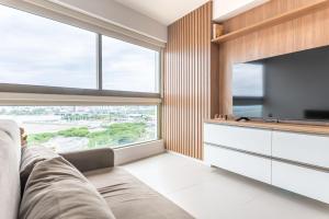 a living room with a couch and a large window at Vista Incrível para o Rio e Mar - PC907 in Recife