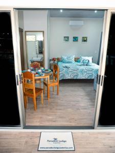 a room with a bed and a table and chairs at Luxury Apartments Nauyaca by Paradiselodge in Platanillo