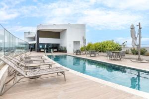 a swimming pool with chairs and tables on a building at Vista Incrível para o Rio e Mar - PC907 in Recife