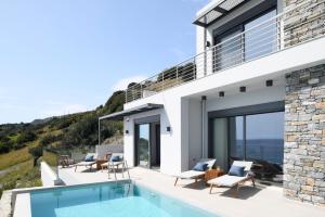 een huis op een heuvel met een zwembad bij Rozites Luxury Beachfront Villa, By Hellocrete in Kerames