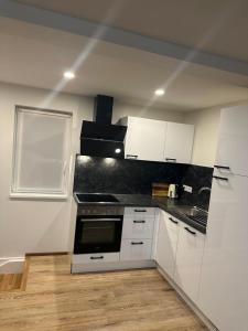 a kitchen with white cabinets and a stove at Alpina Apartment Premium in Feldkirch