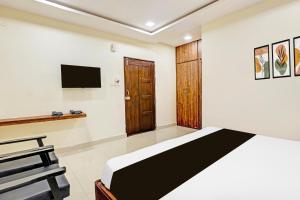 a bedroom with a bed and a tv on the wall at Super Collection O Beach Road Near GITAM in Visakhapatnam +32 photos