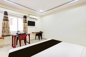 a room with a bed and a table and chairs at Super Collection O Beach Road Near GITAM in Visakhapatnam
