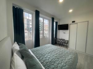 a bedroom with a large bed and two windows at Lord Freitas in Funchal
