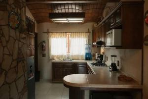 a kitchen with a counter top and a kitchen with a window at Cabaña Real Victoria in Tepatitlán de Morelos +15 photos