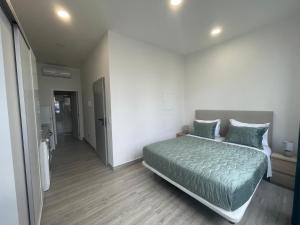 a bedroom with a bed with a green comforter at Lord Freitas in Funchal +4 photos