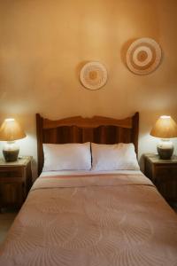 a bedroom with a bed with two lamps on two tables at Cabaña Real Victoria in Tepatitlán de Morelos