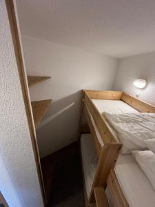 a small room with a bunk bed and shelves at Appartement pied pistes à Val thorens in Val Thorens +8 photos