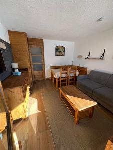 a living room with a couch and a table at Appartement pied pistes à Val thorens in Val Thorens