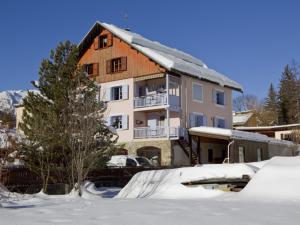 un bâtiment avec de la neige sur le sol devant lui dans l'établissement Appartement sur 2 niveaux, 3 pièces avec Wi-Fi et parking à Saint-Chaffrey, 6 personnes - FR-1-762-17, à Saint-Chaffrey