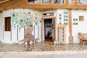 un mural de un árbol al lado de un edificio en Paradiselodge - Poolvilla, en Platanillo