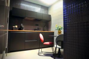 a kitchen with a counter and two chairs and a table at Nenna's Suite Room in Scafati