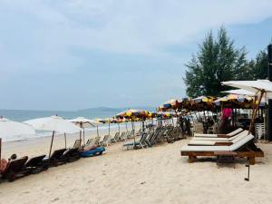 a group of chairs and umbrellas on a beach at Sandline Cabin Bangtao Just 20m from the Beach in Bang Tao Beach +4 photos