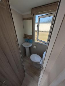 a small bathroom with a toilet and a sink at Family Friendly Caravan in Burnham on Sea in Burnham on Sea +10 photos