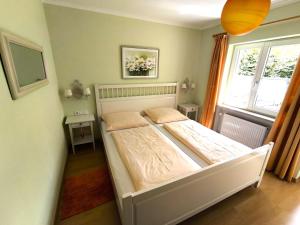 a bedroom with a white bed in a room at Ferienwohnungen Haus Irene in Bodenmais +27 photos