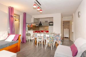 a living room with a table and a kitchen at L'appartement du Berger in La Correrie +13 photos