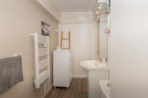 a white bathroom with a sink and a toilet at L'appartement du Berger in La Correrie