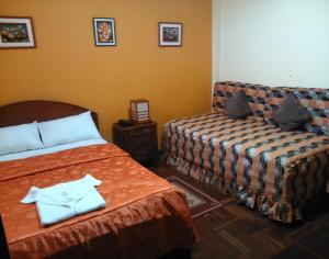 Habitación de hotel con 2 camas y sofá en Hostal Bona Nit, en Trujillo