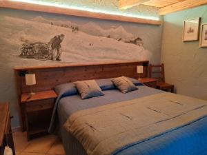 a bedroom with a bed with a painting on the wall at L'Abreny in Brusson