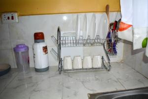 a kitchen counter with a sink and a rack with utensils at Deluxe Stays in Nakuru
