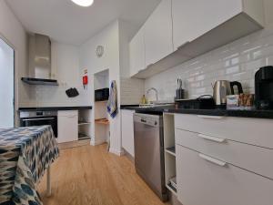 a kitchen with white cabinets and a counter top at Market Downtown T3 in Funchal