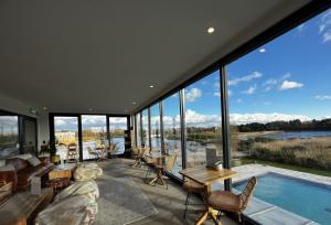 ein Wohnzimmer mit einem Pool und großen Fenstern in der Unterkunft Equinox in Dorchester