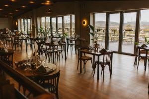 a dining room with tables and chairs and windows at The Brewhouse in Doddington
