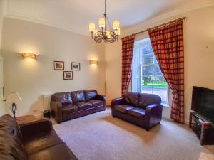 a living room with leather furniture and a window at Hillside House in Saline