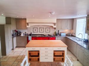 a kitchen with white cabinets and a red stove at Hillside House in Saline
