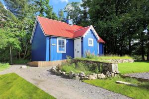 a blue shed with a red roof in a yard at Ardshiel in Foyers