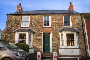 a stone house with a green door on a street at Amesbury Newport, Pembrokeshire in Newport Pembrokeshire +28 photos