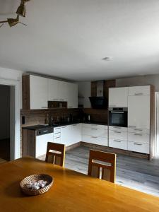 a kitchen with white cabinets and a table with chairs at Boardwalk center in Mayrhofen