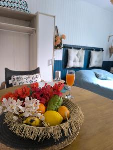 a plate of fruit and vegetables on a table in a room at Cascade et Paille-en-queue - Studio in Hell-Bourg