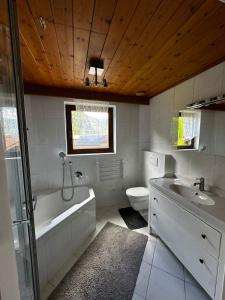 a bathroom with a tub and a sink and a toilet at Boardwalk center in Mayrhofen
