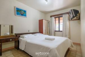 a bedroom with a large white bed and a mirror at Casa a 4 min a pé da praia em Porto Belo BRR0097 in Perequê