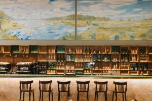 a bar with chairs in front of a wall with a painting at Tailor Room 1 in Lincoln