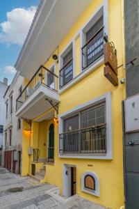 a yellow building with balconies on a street at Historic Izmir Home in Old Town Heart in Konak