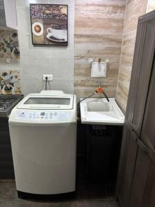 a small kitchen with a stove and a sink at BAM - Hospedajes in Santa Marta