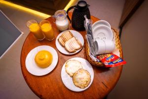 una tavola ricoperta di piatti di cibo e succo d'arancia di Jardins Motel (Adults Only) a Maceió