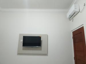 a flat screen tv on a wall in a room at Laisky Residence Bali in Denpasar