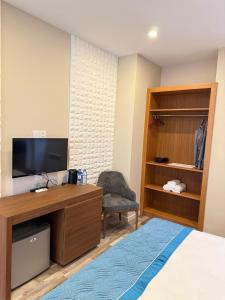 a bedroom with a desk with a tv and a chair at Briiz Hotel Baku in Baku