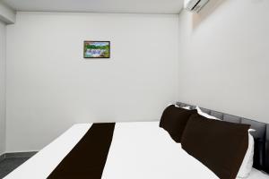 a bedroom with a bed with black and white pillows at Hotel O N Grand in Hyderabad +21 photos
